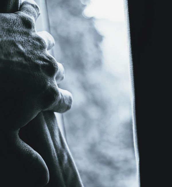 Silhouette of a person in a yoga warrior pose against a dark background with vibrant light.